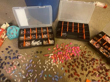 ADHD and Huntington's / Huntington's Disease News / Photo of several storage containers open on the floor next to countless fake nails laid out and organized by color.