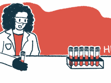 A researcher holds a vial of blood while looking at a rack of filled vials.