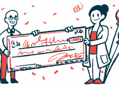 Two people in white coats hold an oversized check.